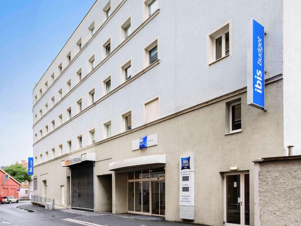 ein großes weißes Gebäude mit blauem Schild drauf in der Unterkunft Ibis Budget Graz City in Graz