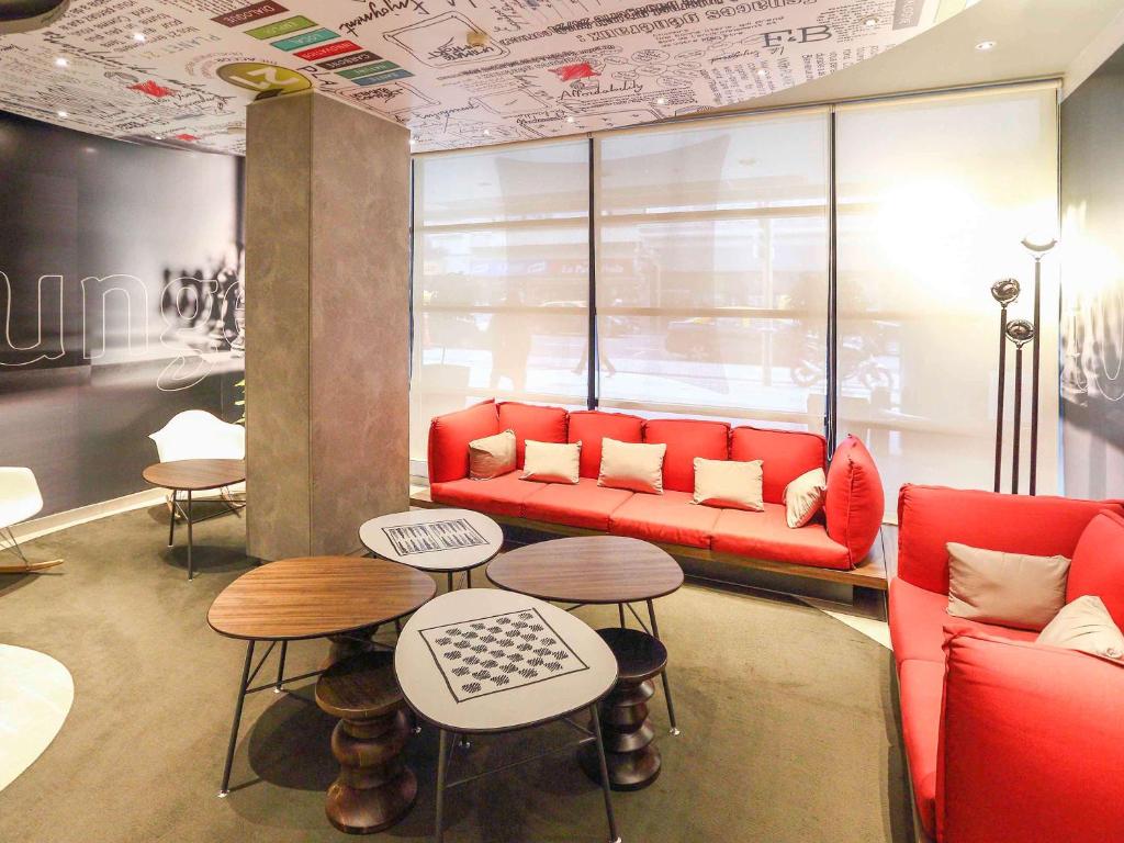 - un salon avec un canapé rouge et 2 tables dans l'établissement ibis Buenos Aires Obelisco, à Buenos Aires