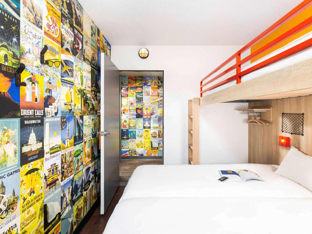 a bedroom with a bed and a wall of stickers at hotelF1 Bordeaux Sud Villenave d'Ornon in Villenave-dʼOrnon