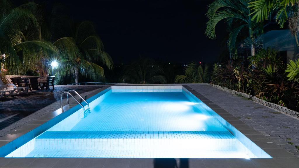 a swimming pool lit up at night at Pemandangan Indah Guest House - Look Out Point Villa- in Pantai Cenang