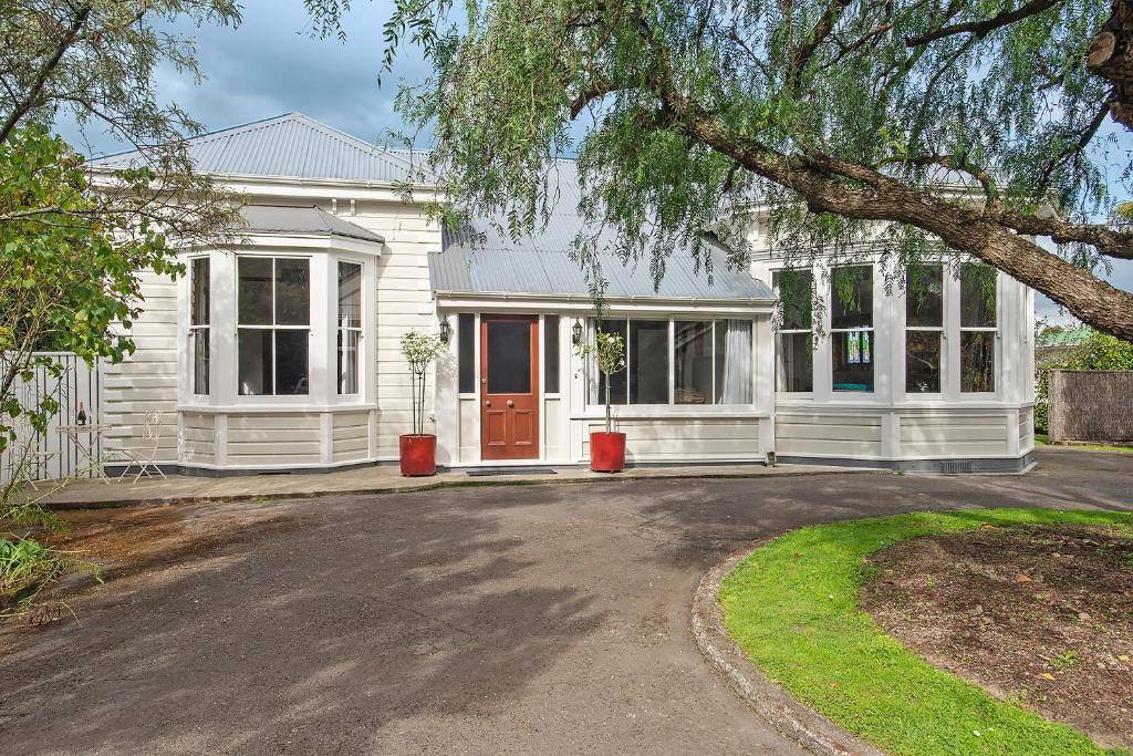 a white house with a driveway in front of it at Pepper Tree Villa in Masterton