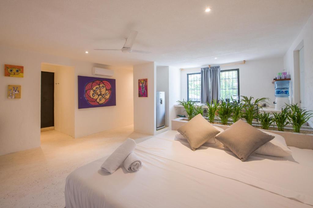 a white bedroom with a large white bed with pillows at Art Studios in Cancún