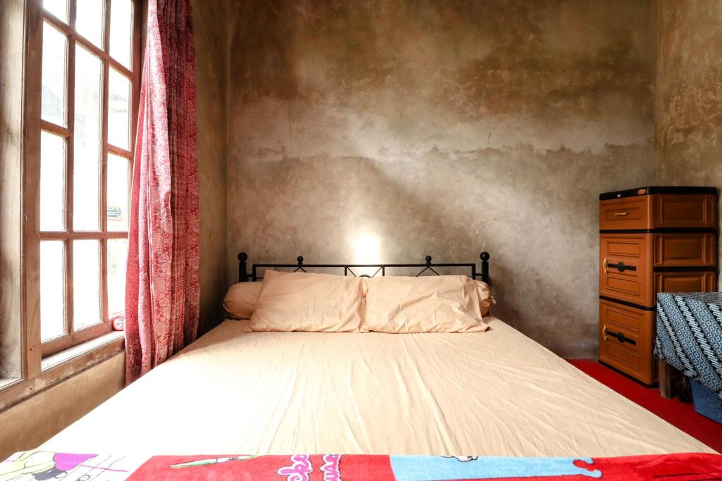 Kasmiyem Homestay في Sermo: غرفة نوم بسرير وخزانة ونافذة