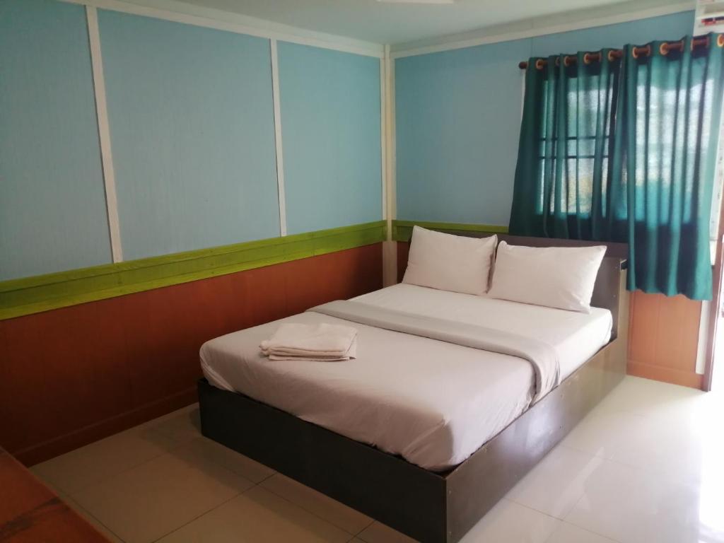 Cette petite chambre comprend un lit avec des draps blancs. dans l'établissement Nang Phraya Resort, à Ban Khok Mai Den (1)