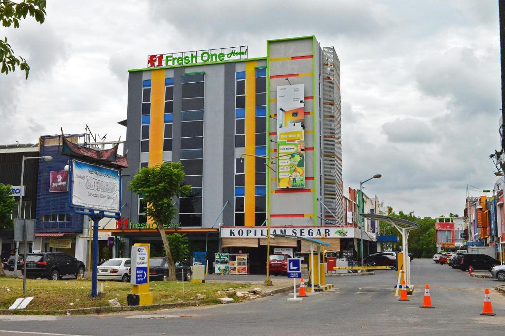 een groot gebouw met een bord aan de zijkant bij Fresh One Hotel in Batam Center