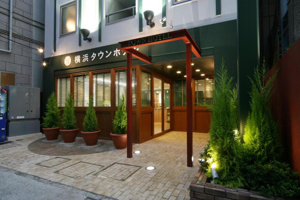 um edifício com vasos de plantas à sua frente em Yokohama Town Hotel em Yokohama