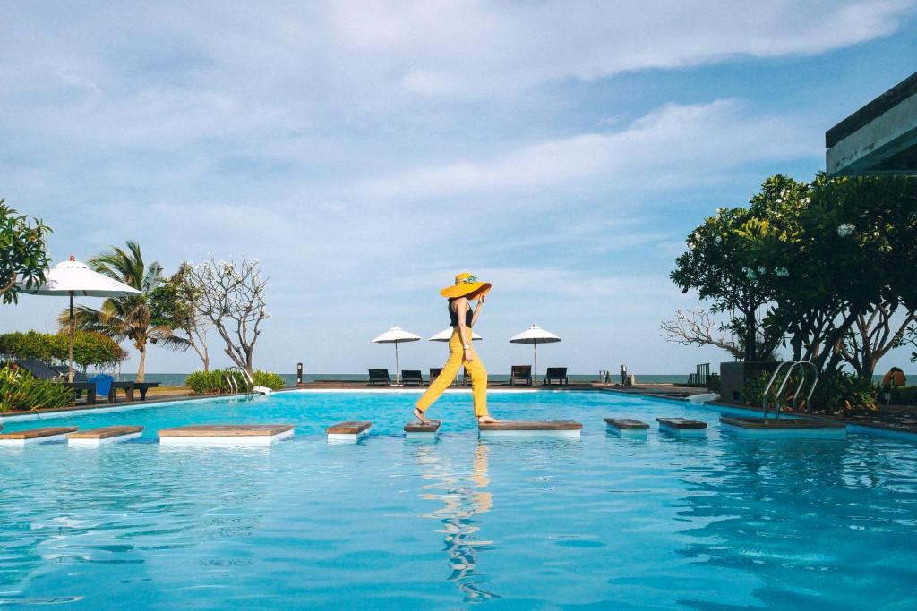i Tara Resort & Spa في هاد تشاو سمران: شخص يمشي في الماء قرب المسبح