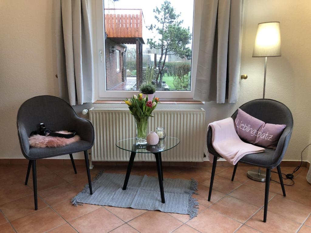 two chairs and a table in a room with a window at Ferienwohnungen Camping SPO OHG in Sankt Peter-Ording