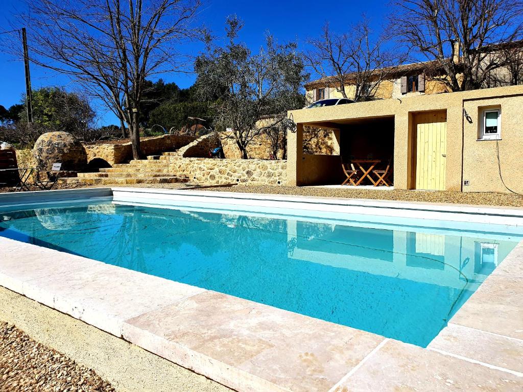 una piscina frente a una casa en Bastide Bellugue Maison d'hôtes réseau Bienvenue à La Ferme à 3 minutes de Lourmarin, en Cadenet