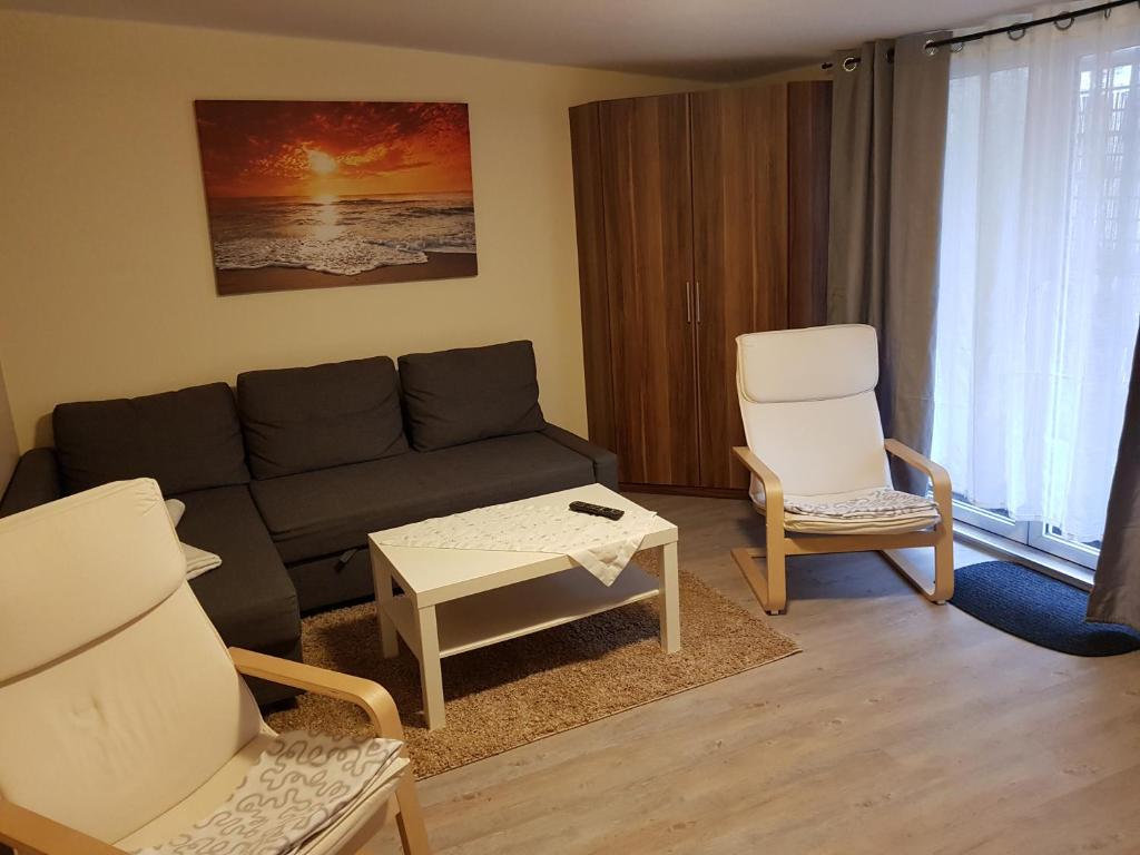 uma sala de estar com um sofá e duas cadeiras em Ferienwohnung 2 in Nähe der Ostsee em Grevesmühlen
