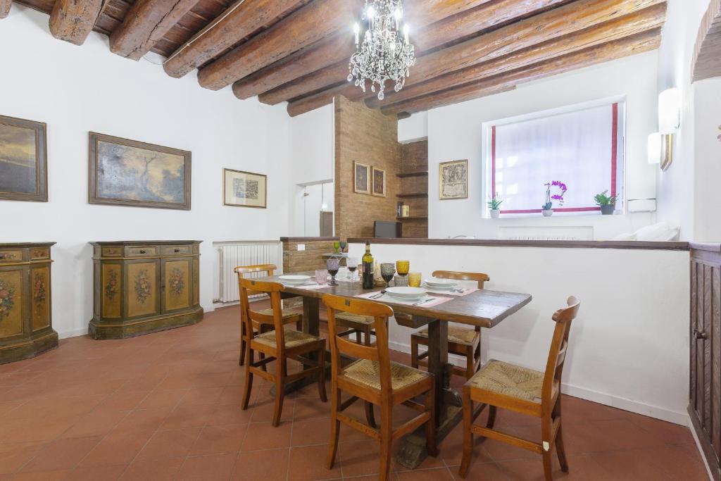 comedor con mesa de madera y sillas en Center ZTL Lovely Apartment, en Ferrara