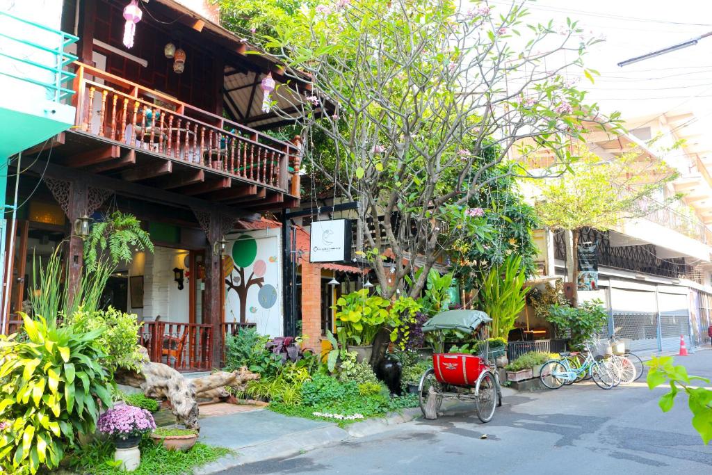 a house with a red bike parked in front of it at Changmoi House (Little Village) in Chiang Mai