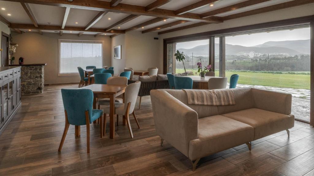 comedor con sofá, mesas y sillas en Hotel Rural Cantexos, en Luarca