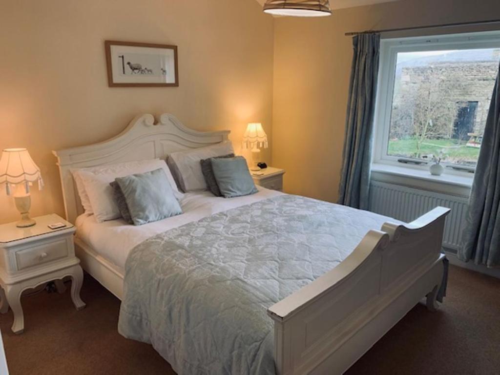 a bedroom with a large bed and a window at Cocketts Hotel in Hawes