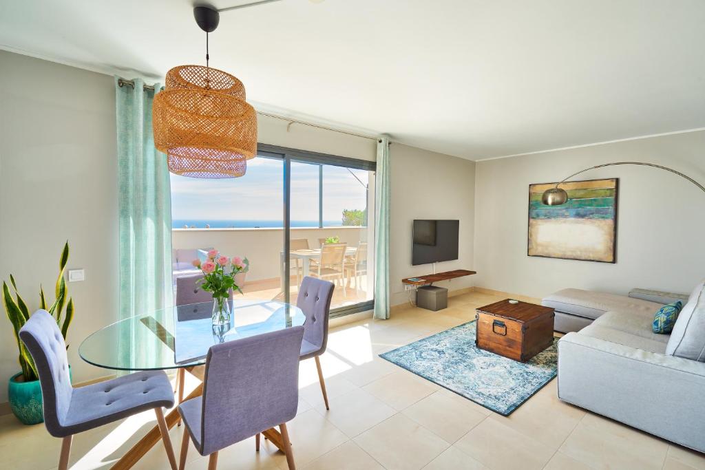 ein Wohnzimmer mit einem Glastisch und Meerblick in der Unterkunft Sea View Penthouse, Pool, Privacy, Benalmadena in Benalmádena