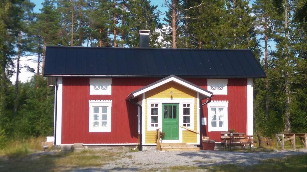 a red and white shed with a green door at Huset Alvina in Korsnäs