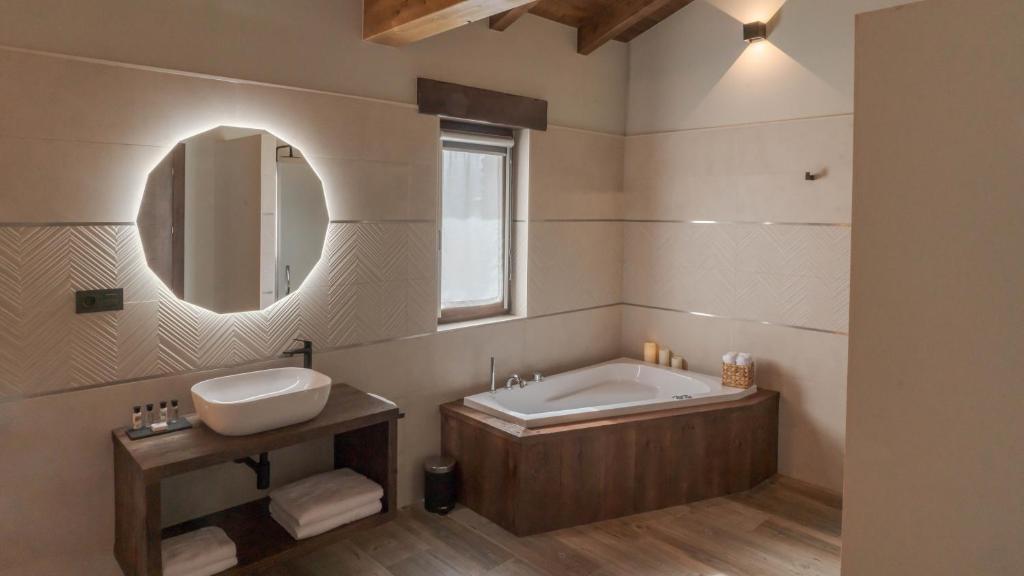Un baño con bañera, lavabo y espejo. en Hotel Rural Cantexos, en Luarca