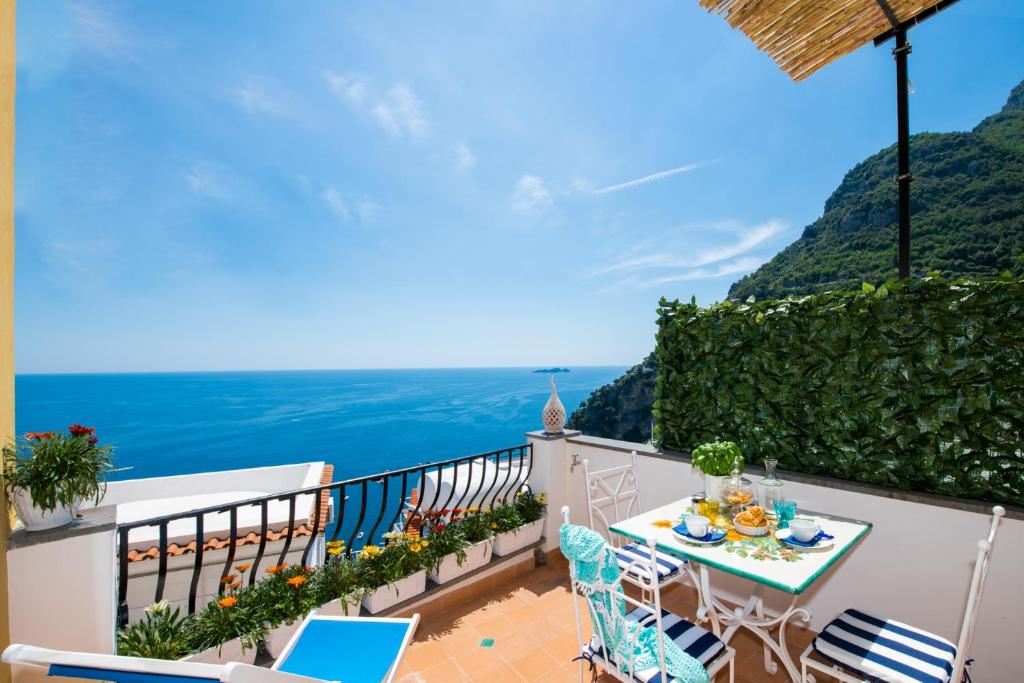a balcony with a table and chairs and the ocean at Blue Dreams in Positano