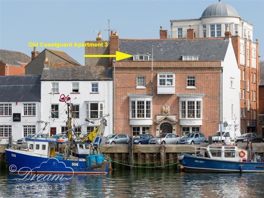 two boats docked in a marina in front of buildings at Old Coastguard Apartment 3 in Weymouth