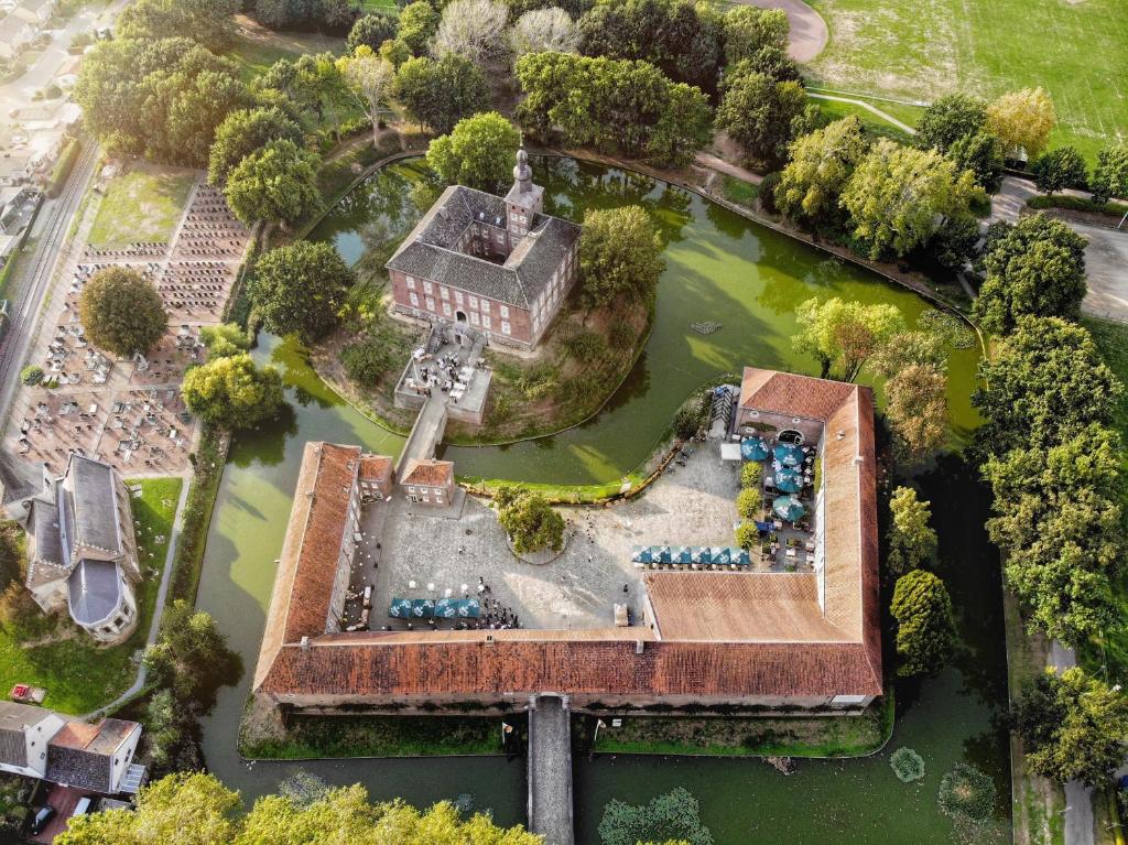 an aerial view of a building in a lake at B&B Kasteel Limbricht in Limbricht