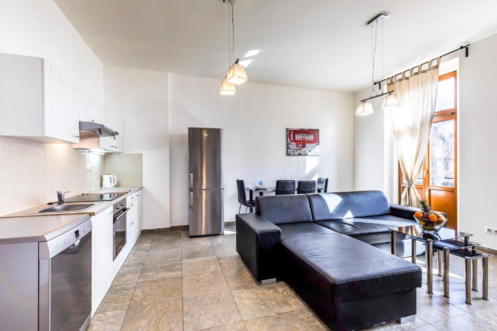 uma cozinha com um sofá e uma mesa num quarto em Teplice Apartments U Schodů em Teplice
