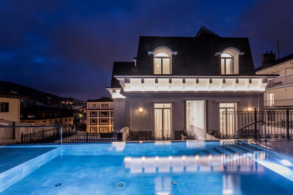 a villa with a swimming pool at night at Villa Eugenia Boutique Hotel in San Sebastián