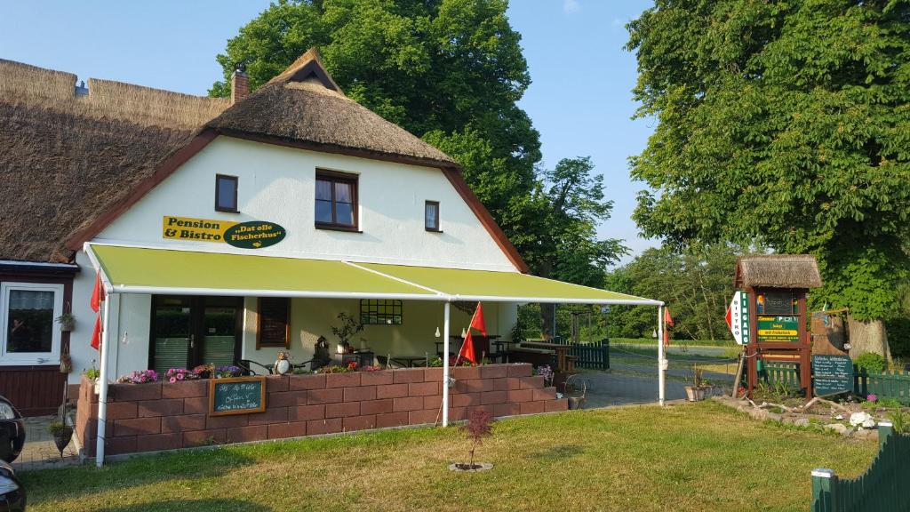 une maison au toit de chaume et un restaurant dans l'établissement Pension und Bistro" Dat olle Fischerhus", à Ralswiek