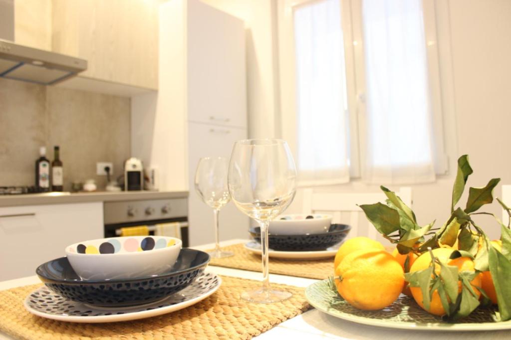 una cocina con una mesa con platos y copas de vino en La Casa del Nespolo, en Ragusa