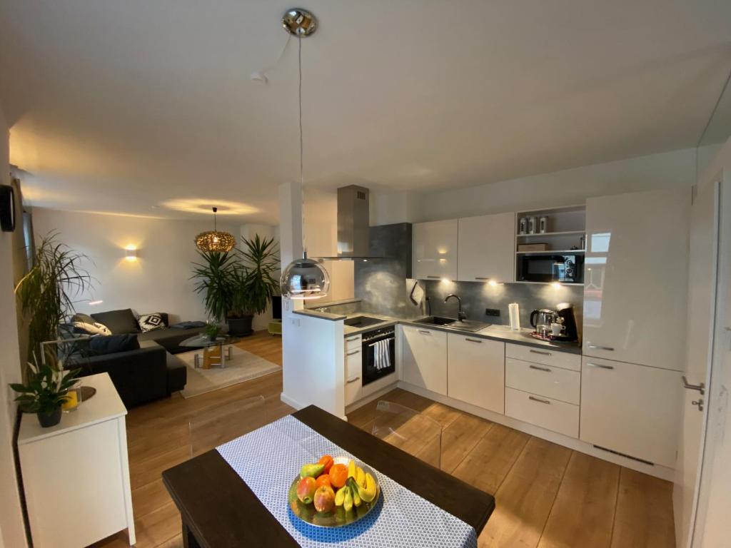 a kitchen and living room with a bowl of fruit on a table at Schwalm-Apartment Treysa in Schwalmstadt
