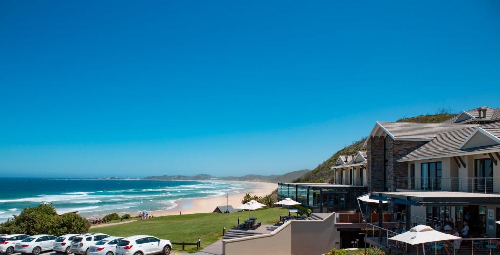 クニスナにあるBrenton Haven Beachfront Resortの建物の前に車を停めたビーチの景色