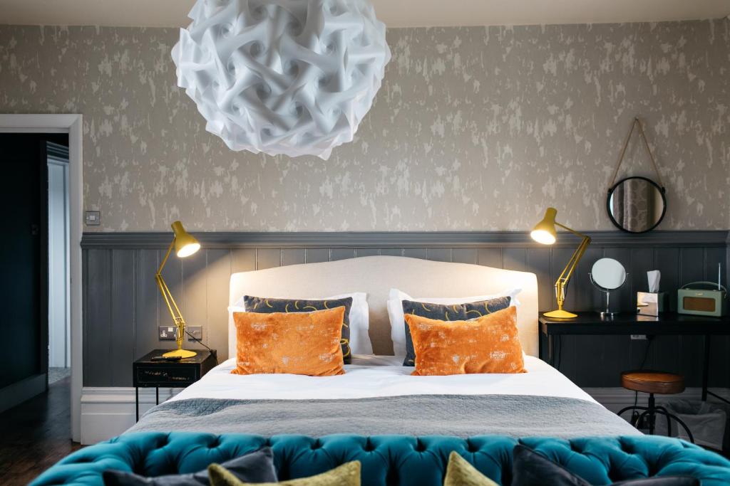 a bedroom with a large bed with orange pillows at The Bull in Ditchling