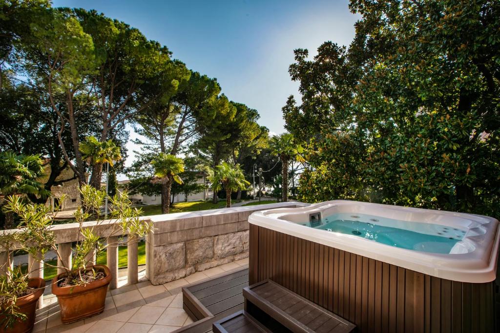 a hot tub on a patio with trees at Amadria Park Hotel Sveti Jakov in Opatija