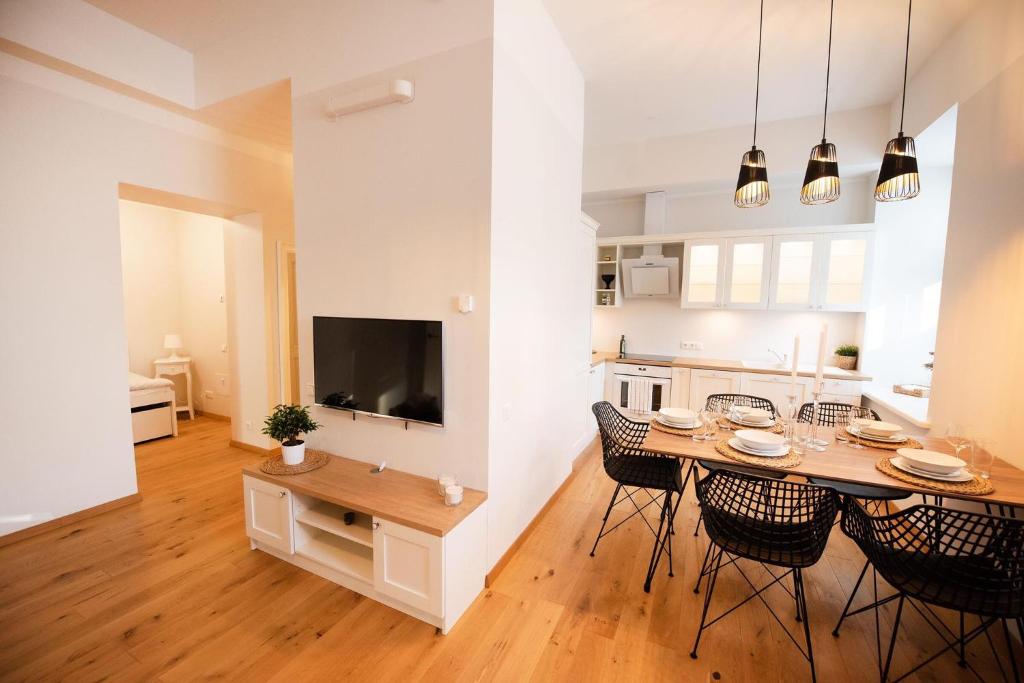 Lossi 32 Lux Apartment في تارتو: مطبخ وغرفة طعام مع طاولة وكراسي