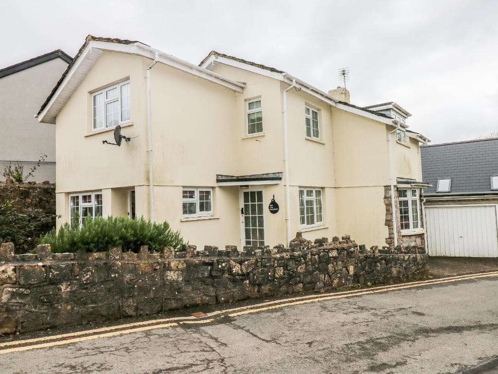 a white house behind a stone wall at The Old Bakehouse in Llantwit Major