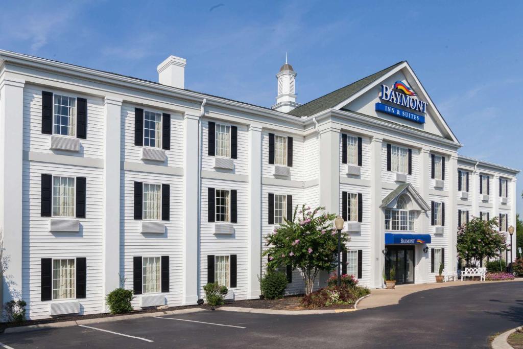 a white building with a blue sign on it at Baymont by Wyndham Columbia Maury in Columbia