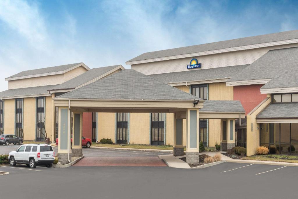 印第安纳波利斯Days Inn by Wyndham Indianapolis Northeast的一家酒店，停车场里停着一辆车