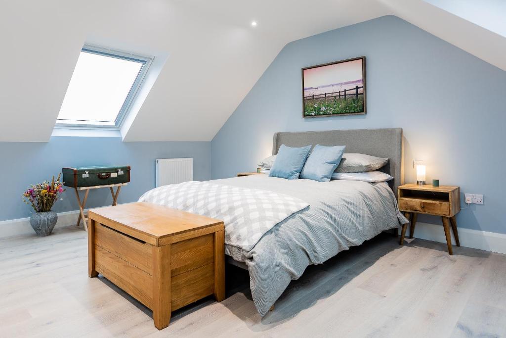 um quarto com uma cama com paredes azuis em Rothbury Hideaway em Rothbury