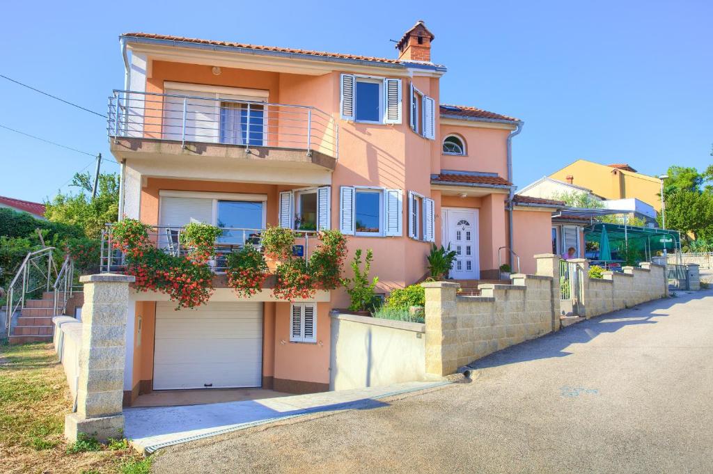 a large pink house with a garage at Apartment Vjeko in Vantačići