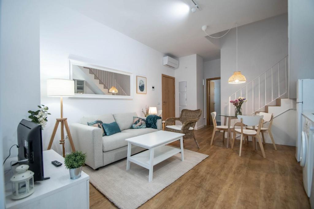 - un salon avec un canapé et une table dans l'établissement Duplex Flamingo Cadiz, à Cadix