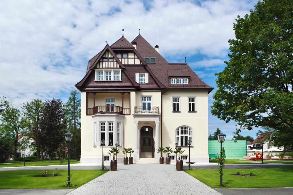 
a large white house with a large window at Hotel Steirerschlössl in Zeltweg
