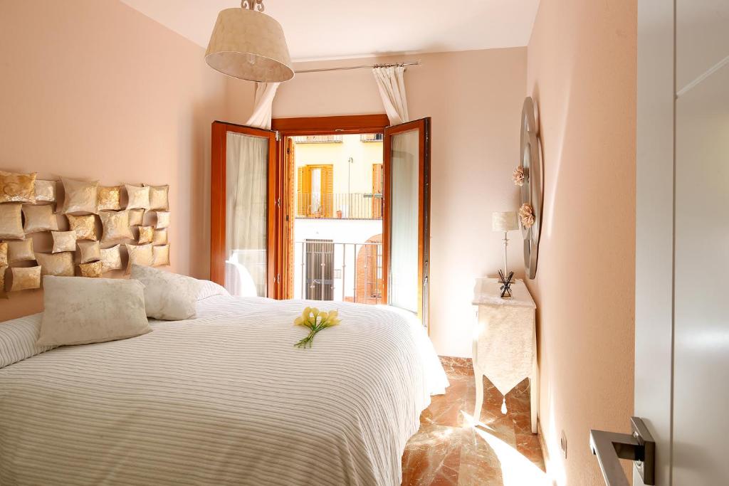 Un dormitorio con una cama blanca con una flor. en Veoapartment Santa Cruz, en Sevilla