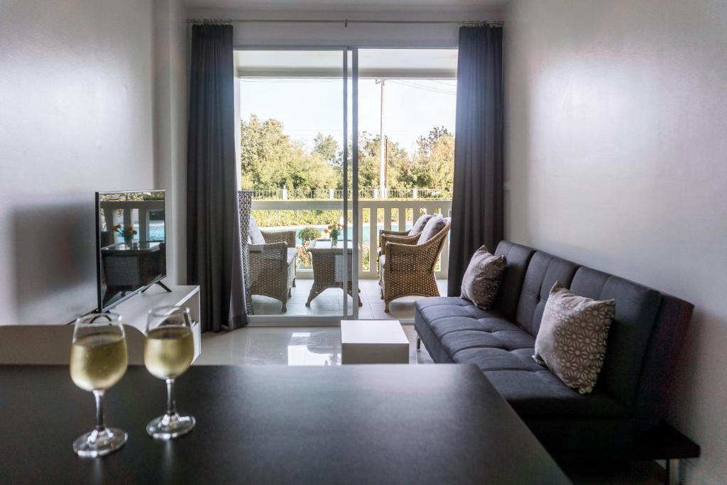 a living room with a couch and two wine glasses at Lägenhet i Blue Marin. Huay Yang, Thailand in Ban Huai Yang