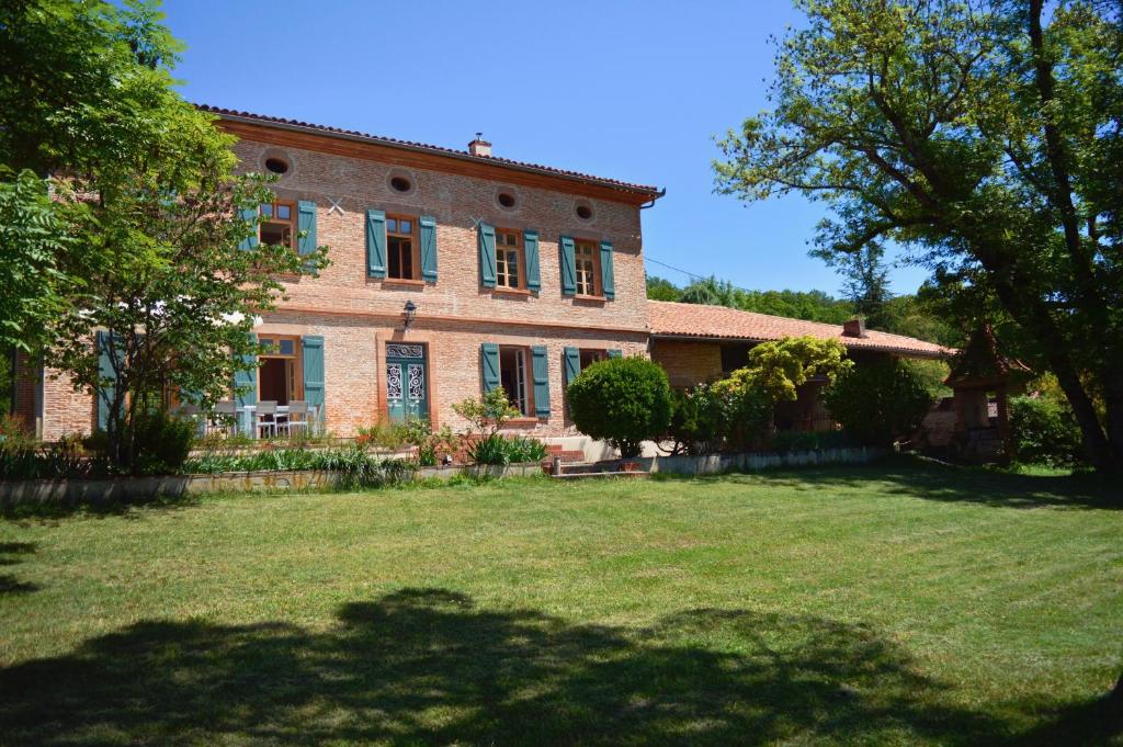 een groot bakstenen huis met een grote tuin bij L'Ostalas in Lafrançaise