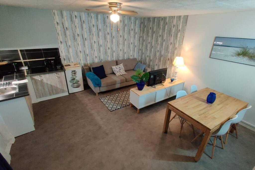 uma sala de estar com um sofá e uma mesa em COTE VACANCES em Chaumont