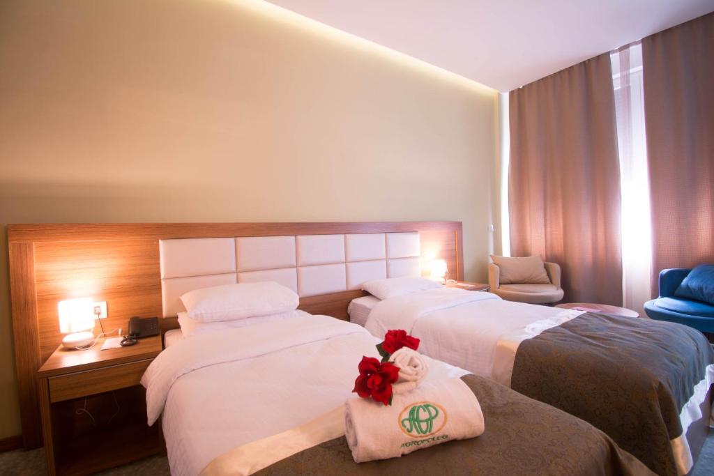 ein Hotelzimmer mit 2 Betten mit Blumen darauf in der Unterkunft Agropolog Hotel & Spa in Želino