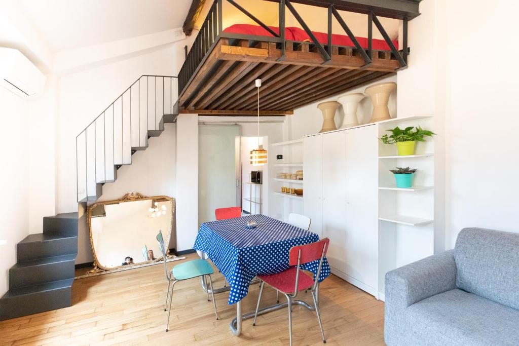 een eetkamer met een tafel en stoelen en een trap bij HouSmart Pratello 48 in Bologna