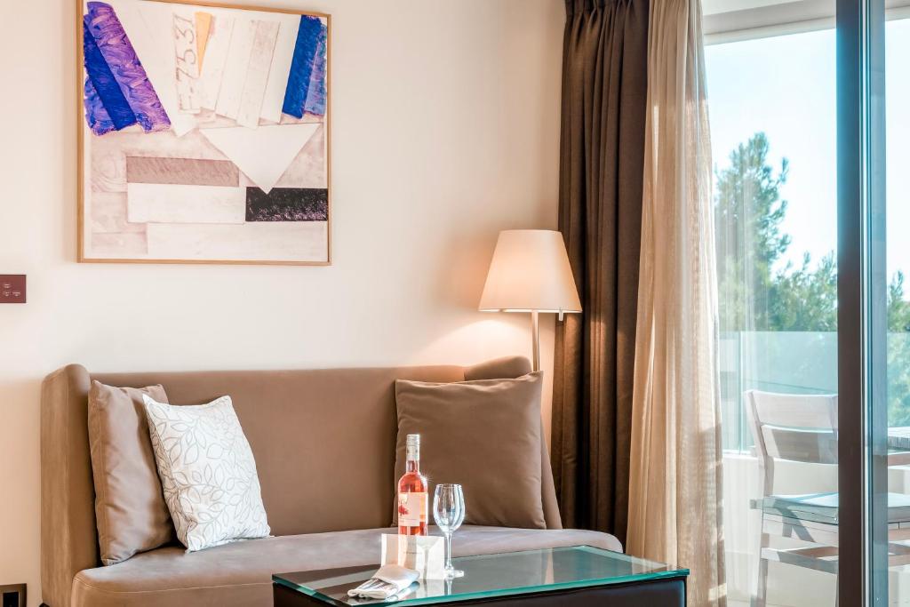 a living room with a couch and a glass table at Somewhere Vouliagmeni in Athens