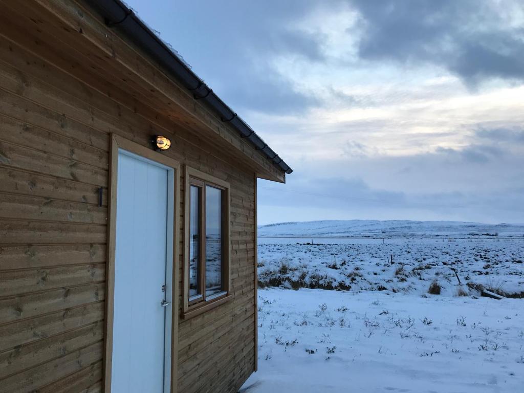 Cabin 1 at Lundar Farm في بورغارنيس: باب لكوخ خشب في الثلج