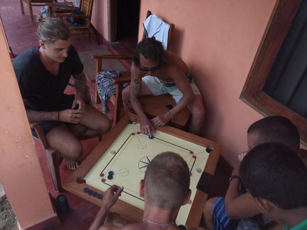un groupe de personnes assises autour d'une table avec un jeu de billard dans l'établissement One More Day Hostel, à Weligama