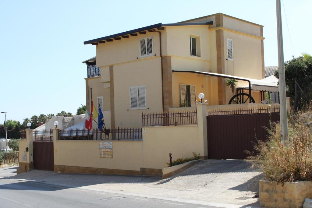 una casa con una valla delante de ella en Villa Mozia, en Marsala